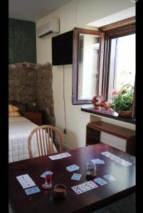 pokój ze stołem i łóżkiem oraz stołem z kartami w obiekcie B&B Home Holiday Villa delle Acacie agriturismo w mieście Sala Consilina
