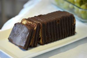 a chocolate cake on a plate on a table at Ilios Hotel in Lákka