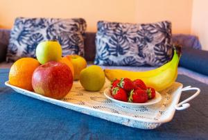 a tray with apples oranges bananas and strawberries on a table at Family Hotel Jemelly in Obzor