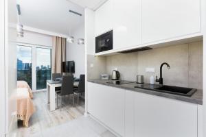 a kitchen and dining room with a view of a bedroom at Apartments with parking Warsaw Business Center by Noclegi Renters in Warsaw