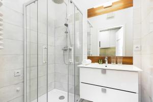 a white bathroom with a shower and a sink at Apartments with parking Warsaw Business Center by Renters in Warsaw