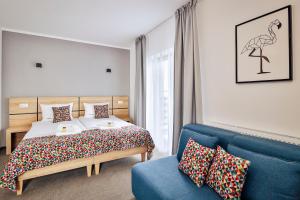 a bedroom with a bed and a blue couch at Targowa37 Uniejow in Uniejow