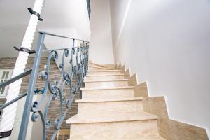 - un escalier dans une maison dotée de murs blancs et de sols blancs dans l'établissement Apulian Escapes - Villa sul Mare, à Savelletri di Fasano