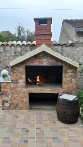 a brick fireplace with a fire in it at Studio Apartment Lile in Trstenik