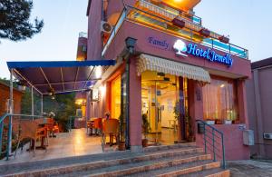 a restaurant with tables and chairs outside of a building at Family Hotel Jemelly in Obzor