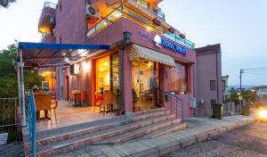 a restaurant with tables and chairs outside of a building at Family Hotel Jemelly in Obzor