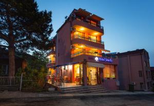 a building with a restaurant in front of it at Family Hotel Jemelly in Obzor