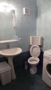 La salle de bains est pourvue de toilettes blanches et d'un lavabo. dans l'établissement Nina, à Pula