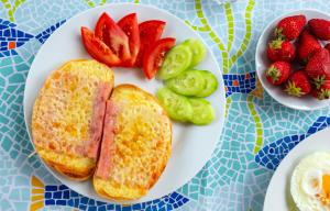 a plate of eggs and toast and strawberries on a table at Family Hotel Jemelly in Obzor