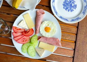 a plate of food with eggs cheese and fruit at Family Hotel Jemelly in Obzor
