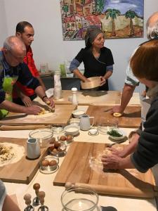 un grupo de personas de pie alrededor de una mesa preparando comida en I Tetti di Siciliando, en Módica