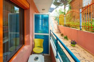 a yellow chair sitting on a balcony next to a window at Family Hotel Jemelly in Obzor