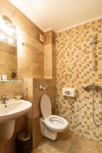 a bathroom with a toilet and a sink at Family Hotel Jemelly in Obzor