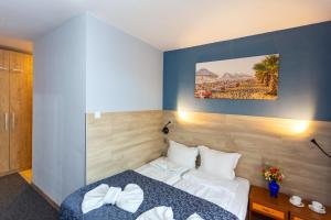 a hotel room with a bed and a painting on the wall at Family Hotel Jemelly in Obzor