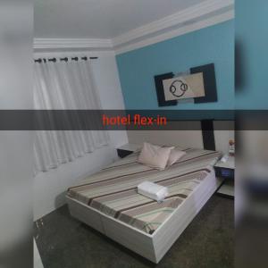 a bedroom with a bed with a hotel hay in at Hotel Flex In in Osasco
