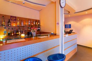 a bar with a clock on the wall at Family Hotel Jemelly in Obzor