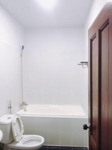 a bathroom with a toilet and a bath tub at Khách sạn Mai Lan in Ho Chi Minh City