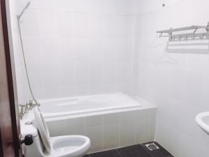 Un baño blanco con inodoro y lavabo. en Khách sạn Mai Lan, en Ho Chi Minh 16 fotos más