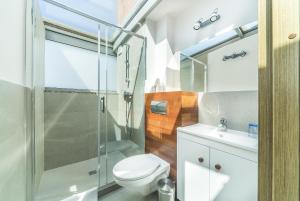 a bathroom with a shower and a toilet and a sink at Marina Apartamenty & Pokoje in Władysławowo