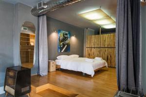 sypialnia z łóżkiem i dużym lustrem w obiekcie Artists’ favorite Spacious Loft near Acropolis!! w Atenach