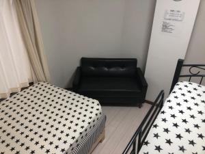 a living room with two beds and a couch at Yasuragi Nakasu in Fukuoka