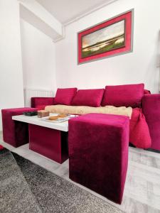 sala de estar con sofá rojo y mesa en Marsala Apartment - Brilliant Apartments en Constanza
