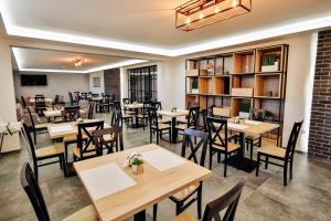 a restaurant with tables and chairs and a library at Targowa37 Uniejow in Uniejow