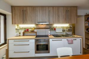 a kitchen with white appliances and wooden cabinets at Nono Mario in Piran