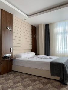 ein Schlafzimmer mit einem großen Bett mit weißer Bettwäsche in der Unterkunft Terzioglu Otel in Hopa
