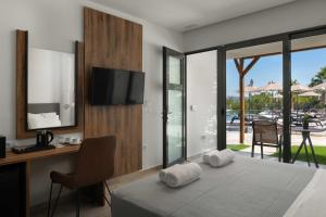 a bedroom with a bed and a desk with towels at Atalanti Boutique Hotel - Adults Only in Faliraki