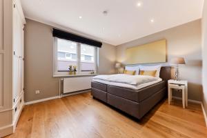 un dormitorio con una cama y una ventana en Astra Maris Apartments, en Büsum