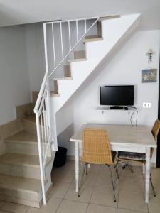 Zimmer mit einem Schreibtisch, einem TV und einer Treppe in der Unterkunft Elisa Home Casa Vacanze in Sottomarina