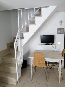 ソットマリーナにあるElisa Home Casa Vacanzeのデスク、テレビ、階段が備わる客室です。