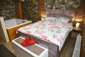 a bedroom with a bed and a bath tub at Hotel ZRINSKI in Koprivnica