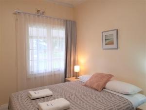 a bedroom with a bed and a lamp at Albany Holiday Units in Albany