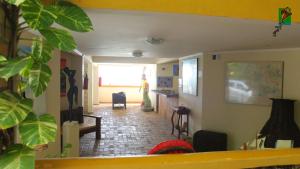 a woman standing in a room with a hallway at Hotel Morro do Careca in Natal