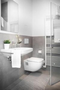 a white bathroom with a toilet and a sink at Favorit Serviced Apartments in Ludwigsburg