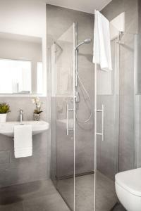 ein Bad mit einer Dusche und einem Waschbecken in der Unterkunft Favorit Serviced Apartments in Ludwigsburg