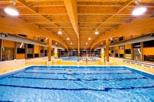 a large swimming pool in a building with a large pool at Holiday Villa Lipno Lake in Lipno nad Vltavou