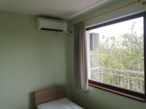 a bedroom with a window and a bed and a balcony at Alfa Guest House - Free Parking in Varna City