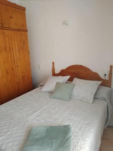 1 dormitorio con 1 cama blanca grande y cabecero de madera en BUHARDILLA PARA DOS EN CAN MINGU, en Besalú