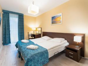 コウォブジェクにあるAquaBaltic Apartments Aquariusのベッドルーム1室(大型ベッド1台、青い毛布付)