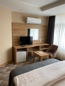 a hotel room with a bed and a desk with a television at Terzioglu Otel in Hopa