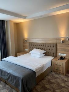 a bedroom with a large bed and two tables at Terzioglu Otel in Hopa