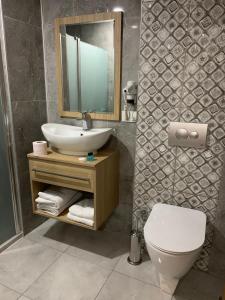 La salle de bains est pourvue d'un lavabo, de toilettes et d'un miroir. dans l'établissement Terzioglu Otel, à Hopa