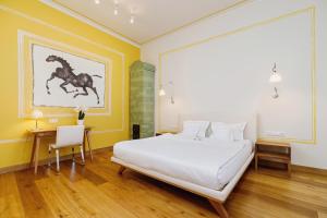 a bedroom with a bed and a painting of a horse on the wall at Apartamenty Bracka 6 in Krakow