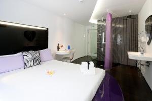 En eller flere senge i et værelse på Absoluto Design Hotel