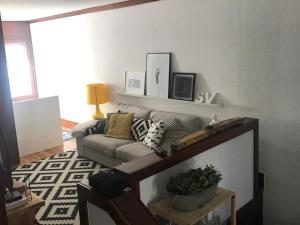 uma sala de estar com um sofá e uma mesa em casa das conchas em Tróia