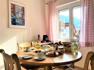 einen Holztisch im Esszimmer mit Fenster in der Unterkunft Apartment Sir George in Garmisch-Partenkirchen