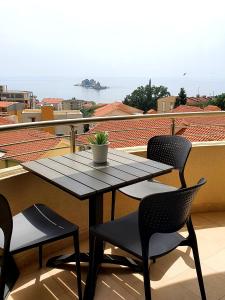 einen Tisch und Stühle auf einem Balkon mit Aussicht in der Unterkunft Anja & Ogo Apartment sea View & Pool in Petrovac na Moru